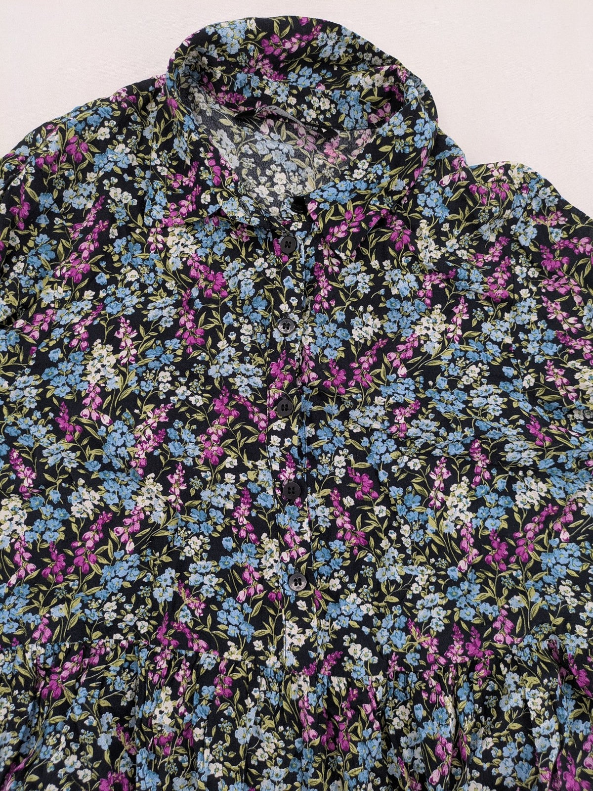 Zara multi-coloured floral mini dress with classic collar and button placket on black background.