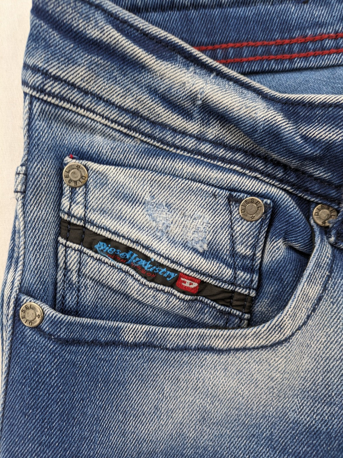Diesel blue straight jeans with distressed details and ripped accents, made of cotton.