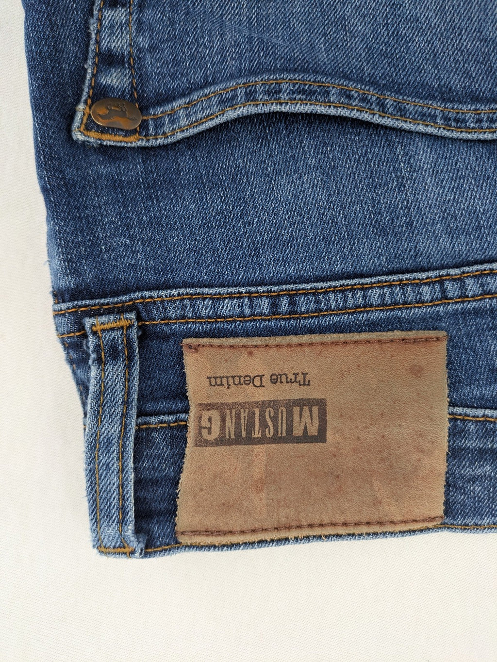 Mustang blue tapered jeans with slim fit, medium rise, and classic denim texture.