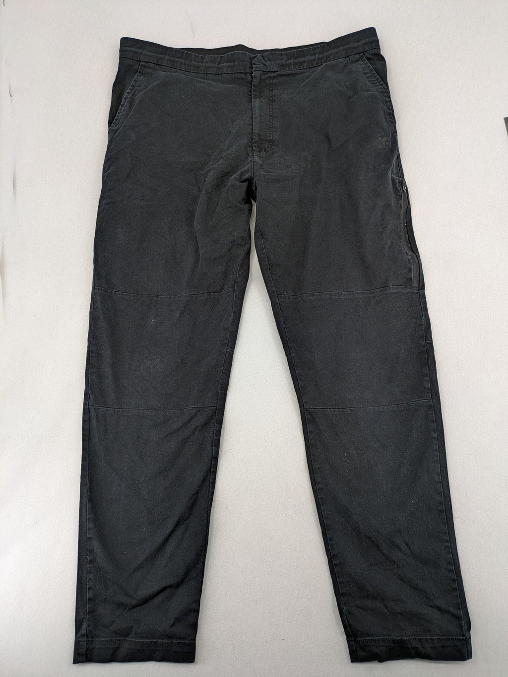 4F black cargo pants with reinforced knees, made from cotton-stretch material.