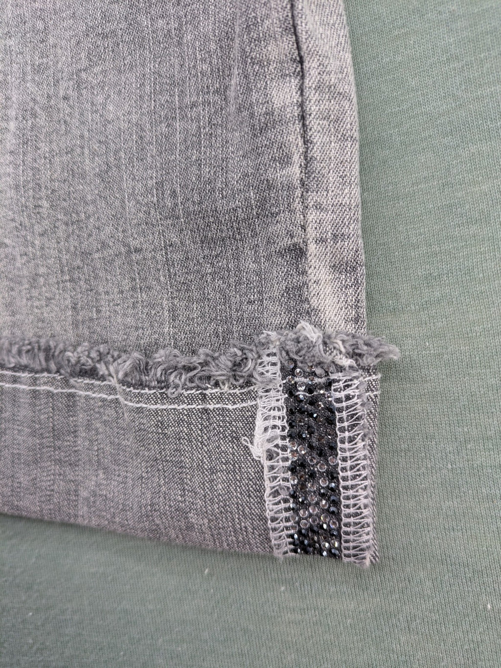 Rick Cardona grey cropped straight jeans with frayed hems and sparkling rhinestone details.