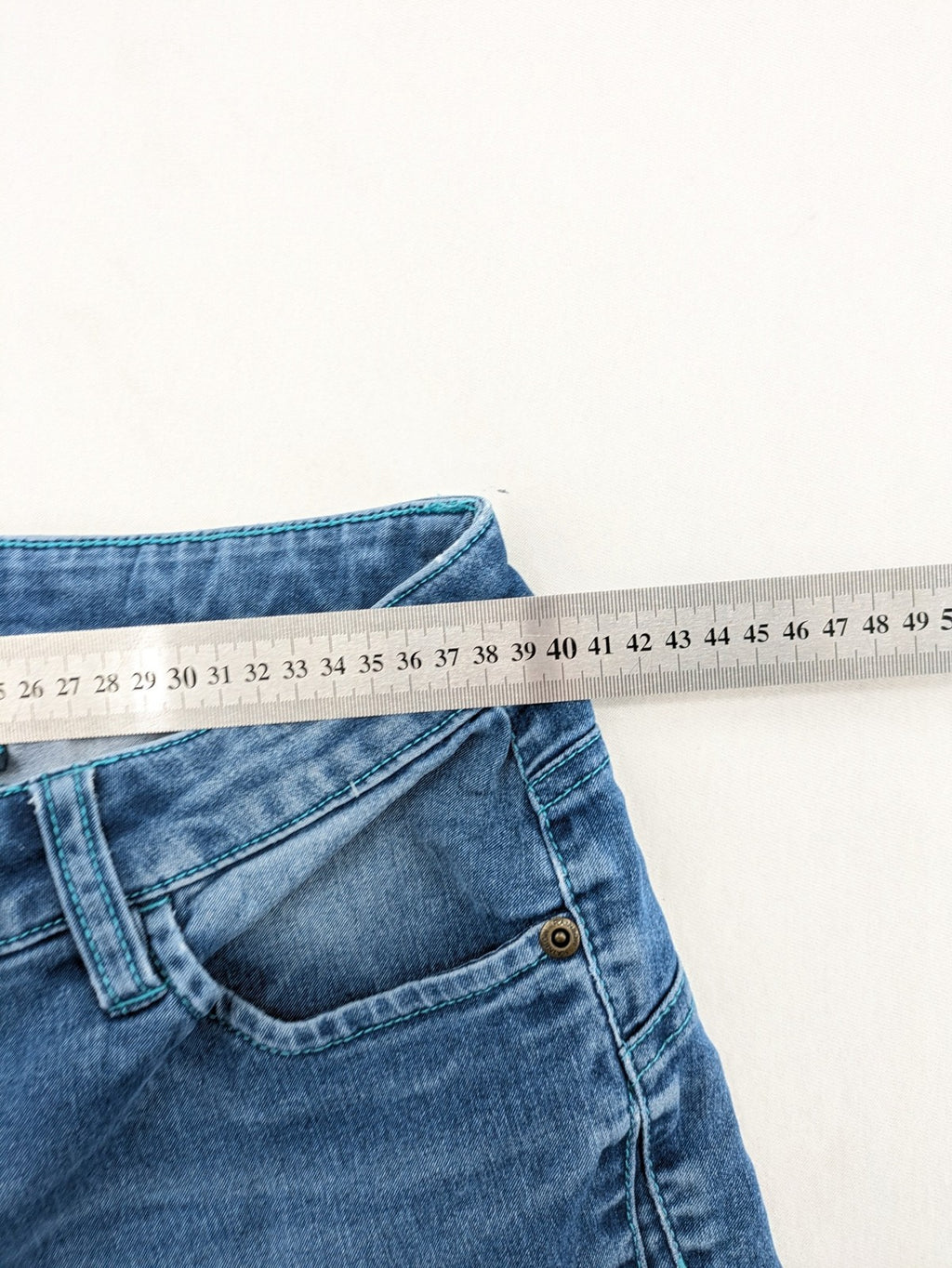 Rainbow blue straight jeans jogger style with button fly and contrasting turquoise stitching.