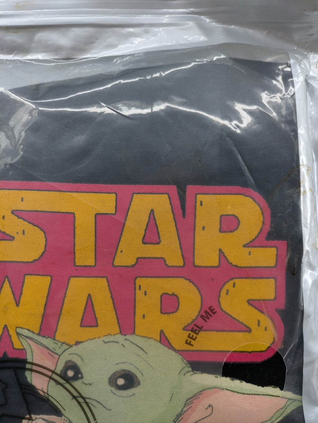Star Wars black t-shirt featuring colorful Grogu graphic and short sleeves.