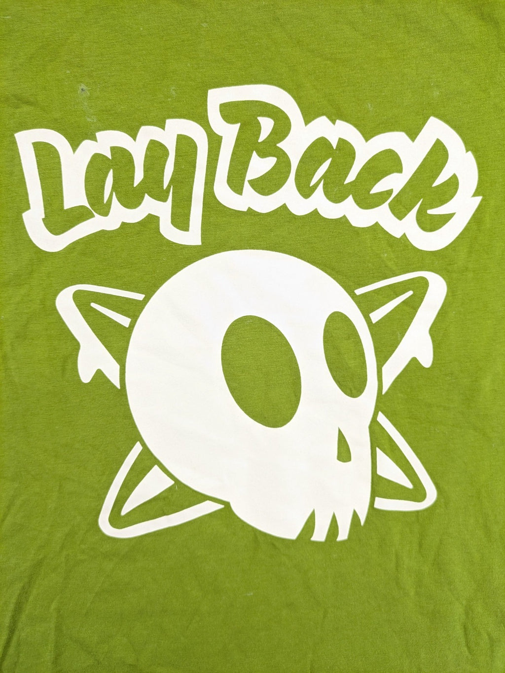 Lay Back green t-shirt with skull graphic, logo print, and short sleeves.