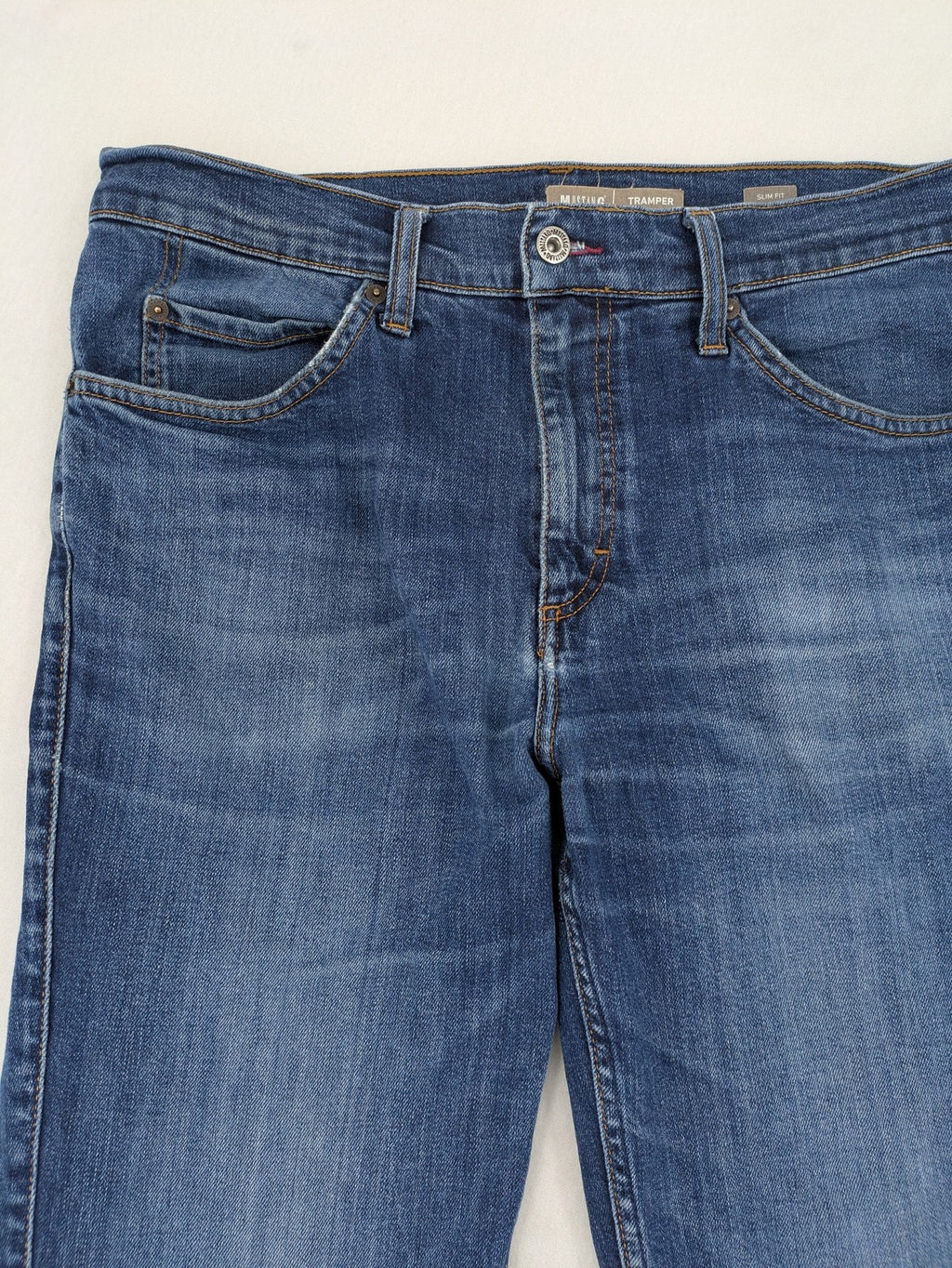 Mustang blue tapered jeans with slim fit, medium rise, and classic denim texture.