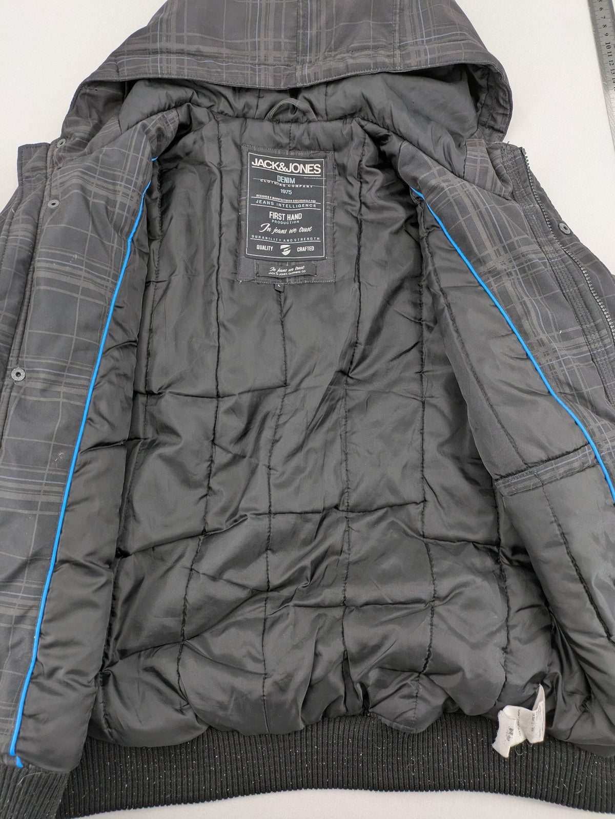 Jack & Jones grey checkered winter jacket with hood, quilted lining, and zip closure.