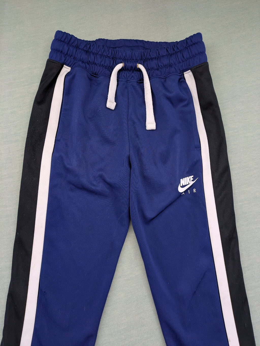 Nike Air blue jogging pants with black and white side stripes, elastic waistband.