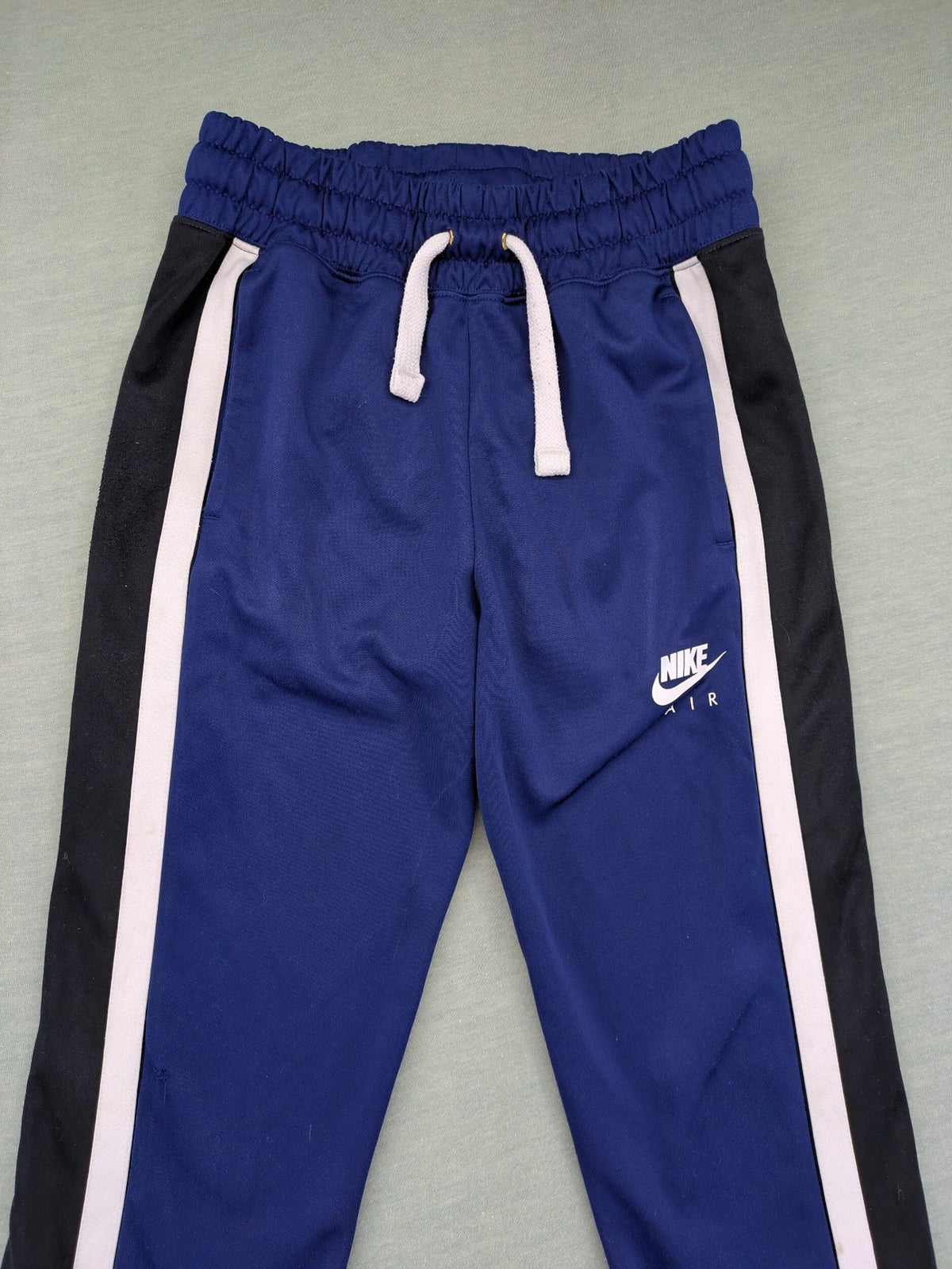 Nike Air blue jogging pants with black and white side stripes, elastic waistband.