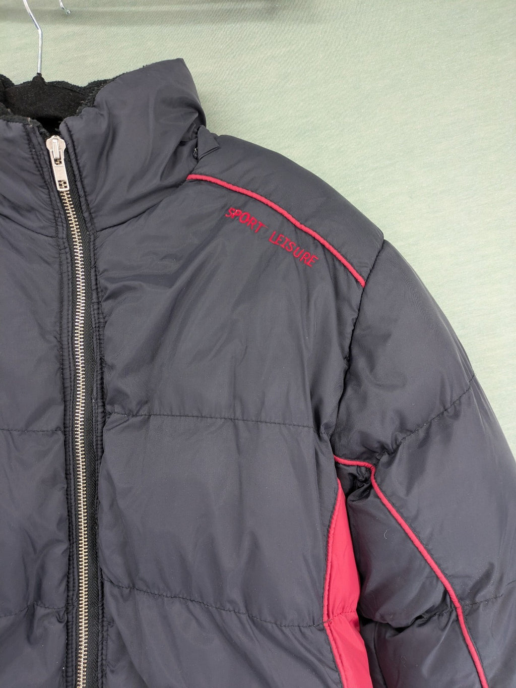 Puffer grey and red jacket with fleece lining, front zipper, and side pockets.