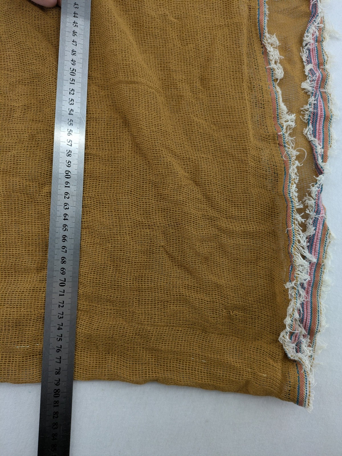 Romano multi scarf ocker with multicolored striped border and fringed edges.