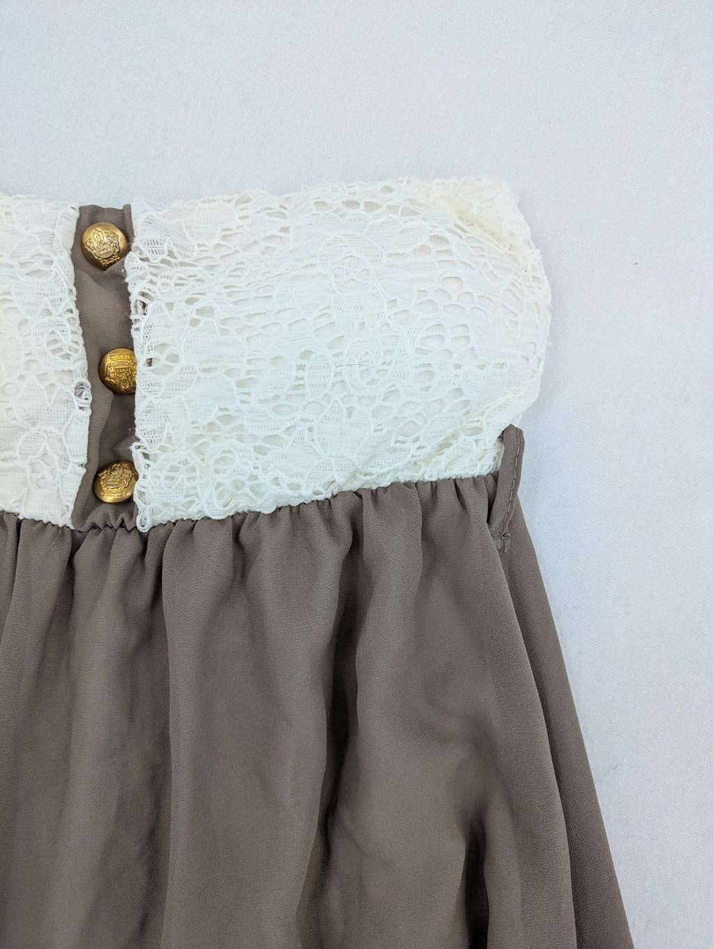 Creme bandeau summer dress in taupe with lace top and decorative gold buttons.