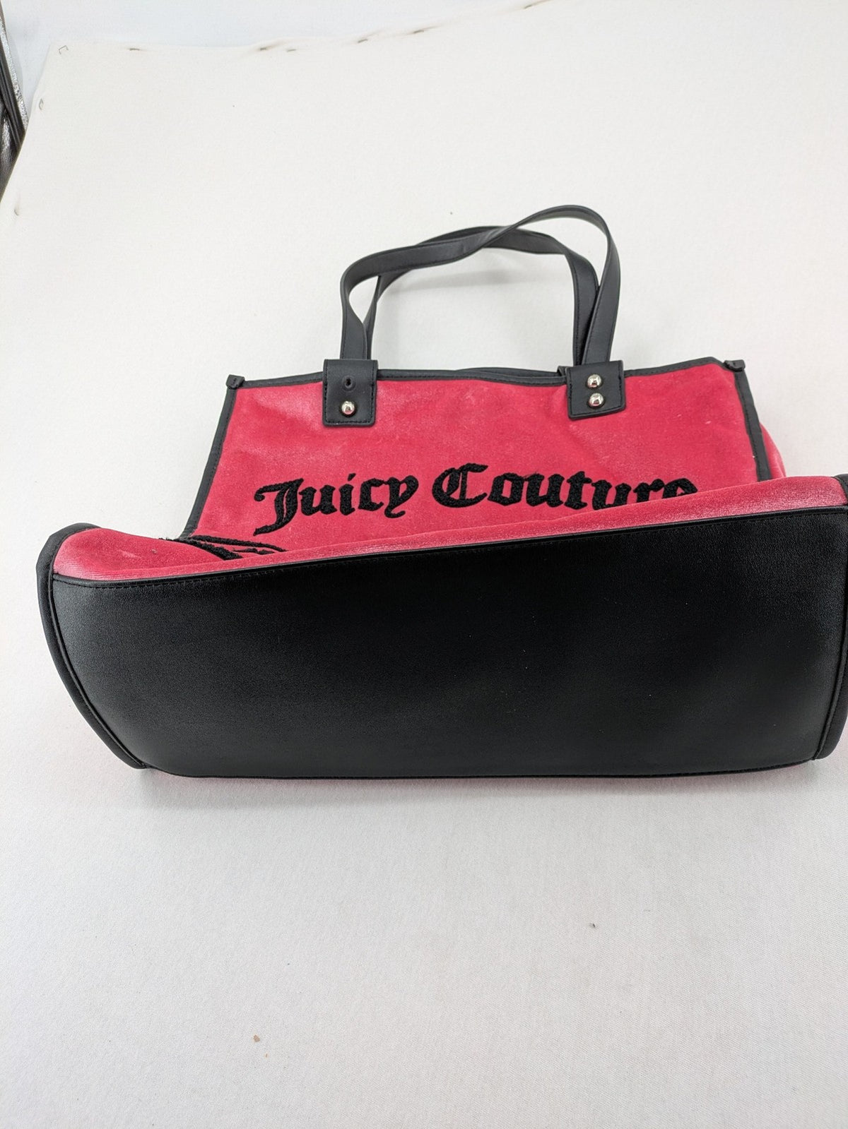 Juicy Couture pink velour handbag with oversized black logo and faux leather straps.