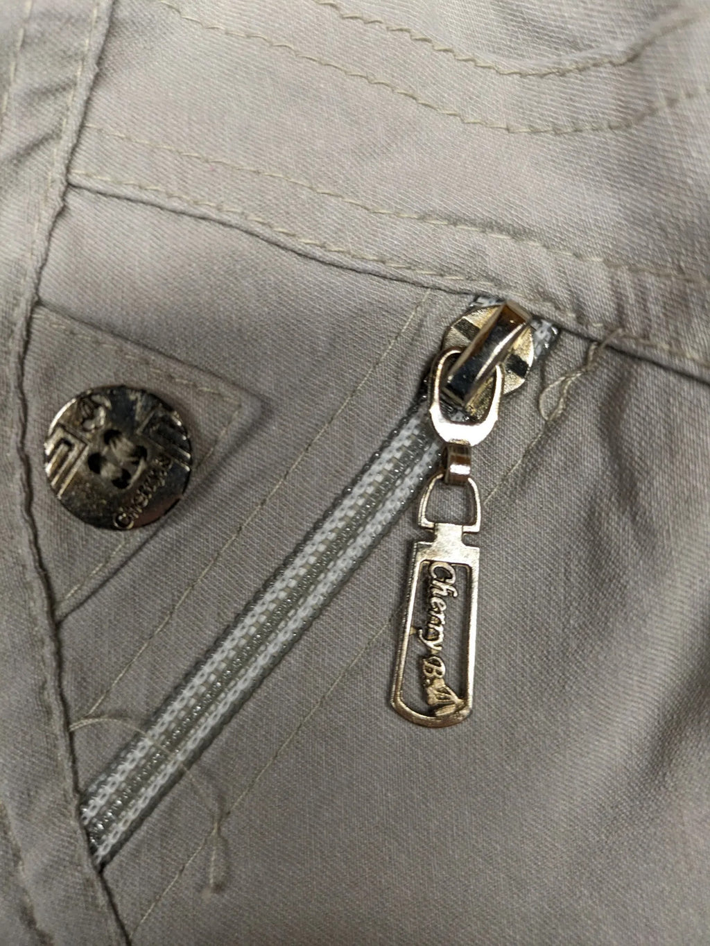 Cherry Berry khaki capri pants with elastic waistband and decorative buttons, featuring logo and zip pockets.