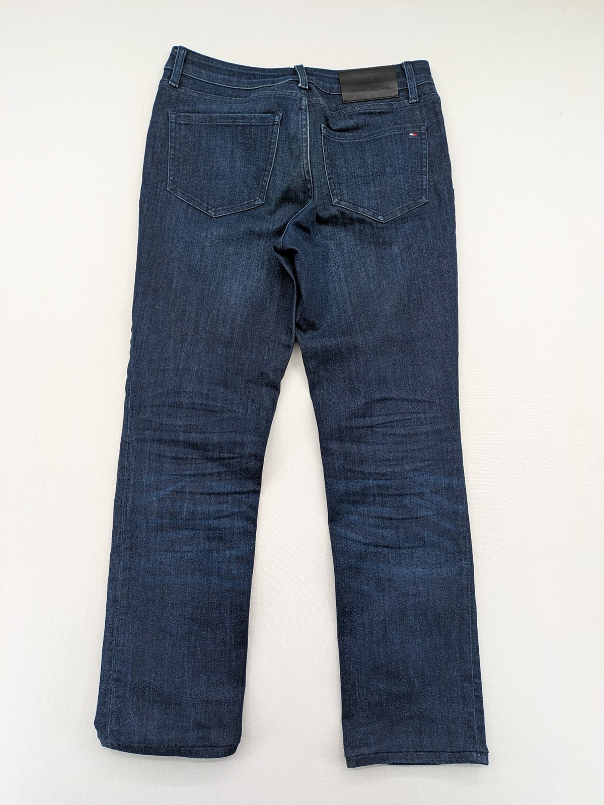 Tommy Hilfiger blue straight jeans with iconic logo and dark wash denim finish.