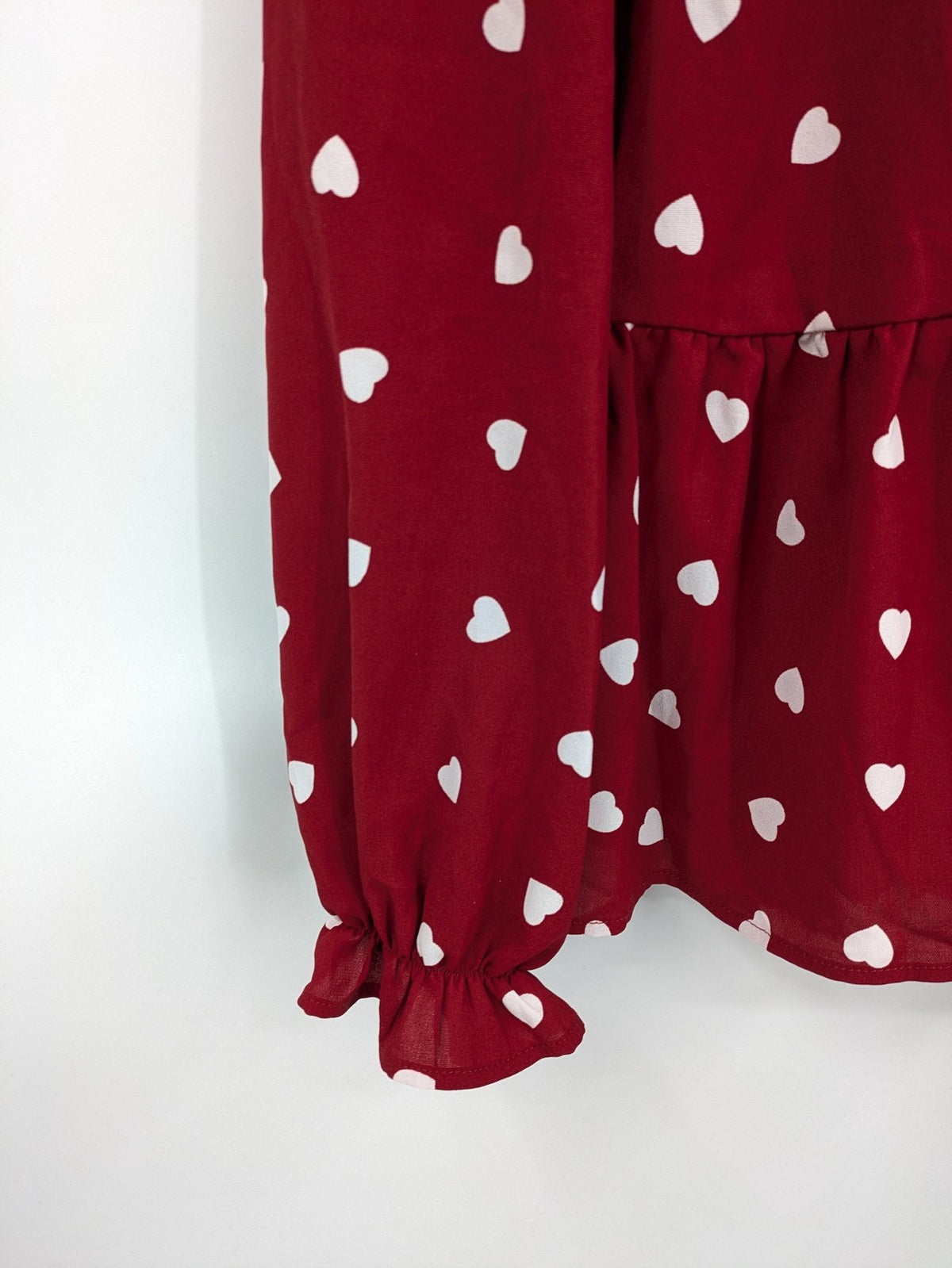 SHEIN burgundy top with white heart pattern and ruffled neckline detail.
