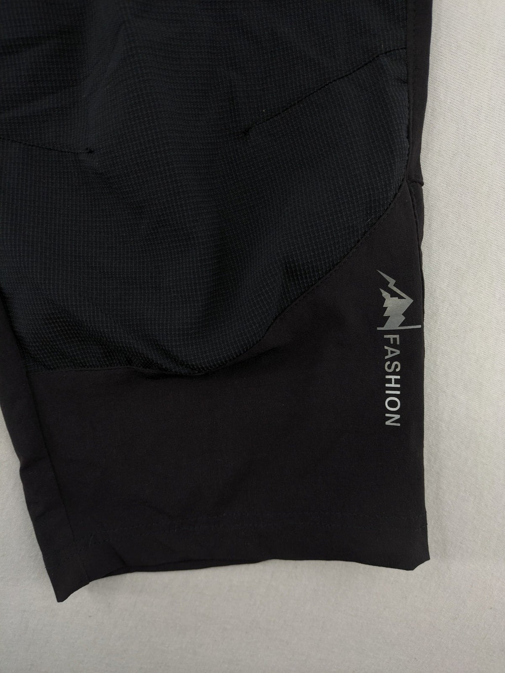 Outdoor black capri pants with elastic waistband and multiple zippered pockets.