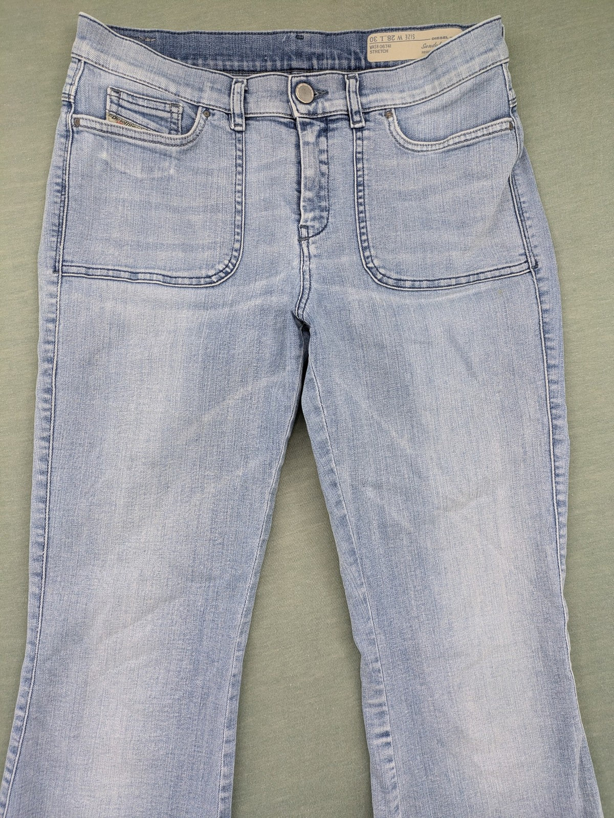 Diesel blue bootcut jeans with white patch pockets and regular waist, stylish stretch material.