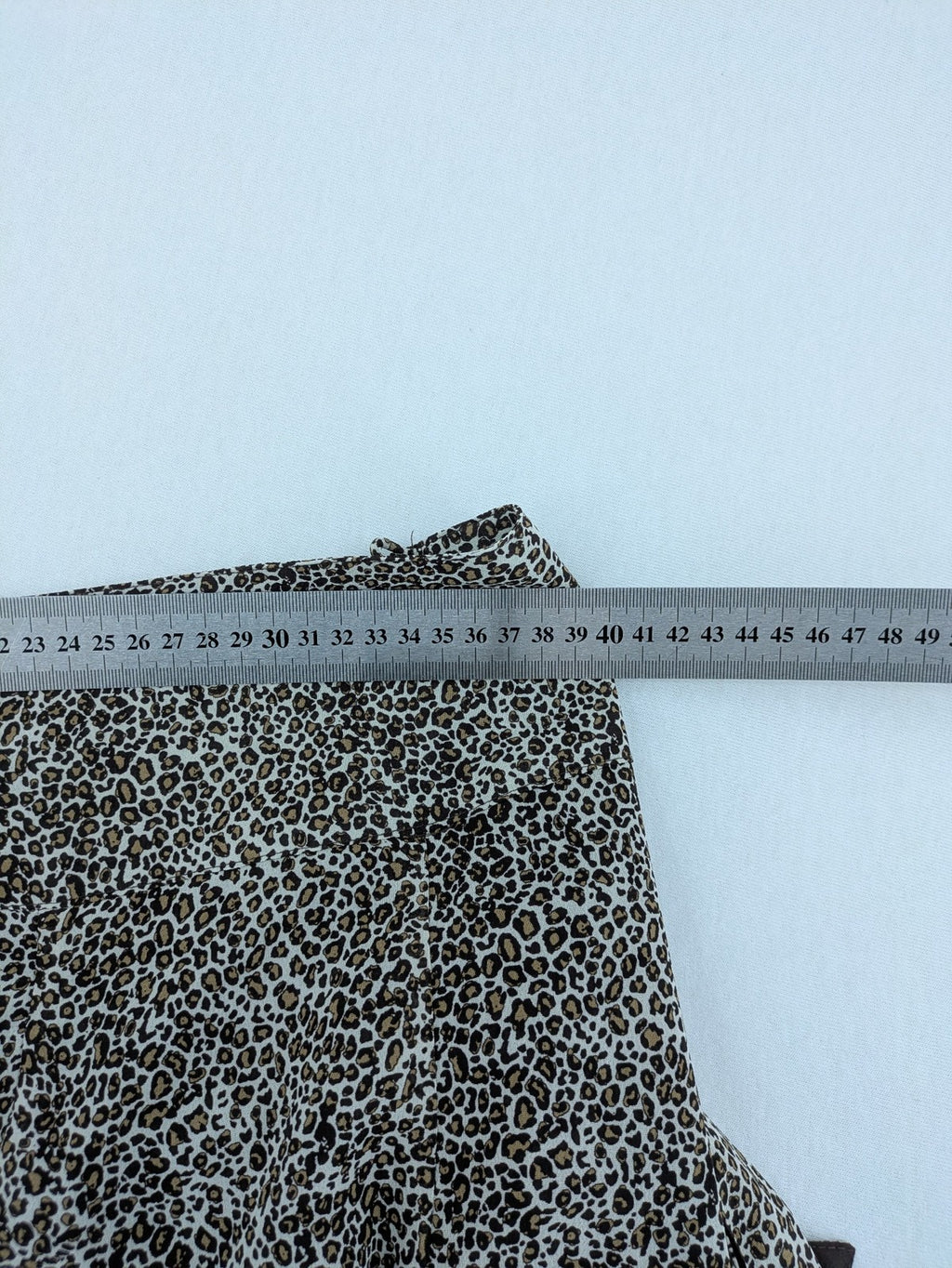 H&M women's A-line skirt beige brown leopard print ruffled hem and side tie detail.
