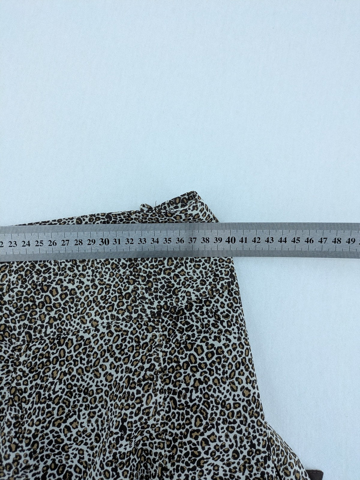 H&M women's A-line skirt beige brown leopard print ruffled hem and side tie detail.