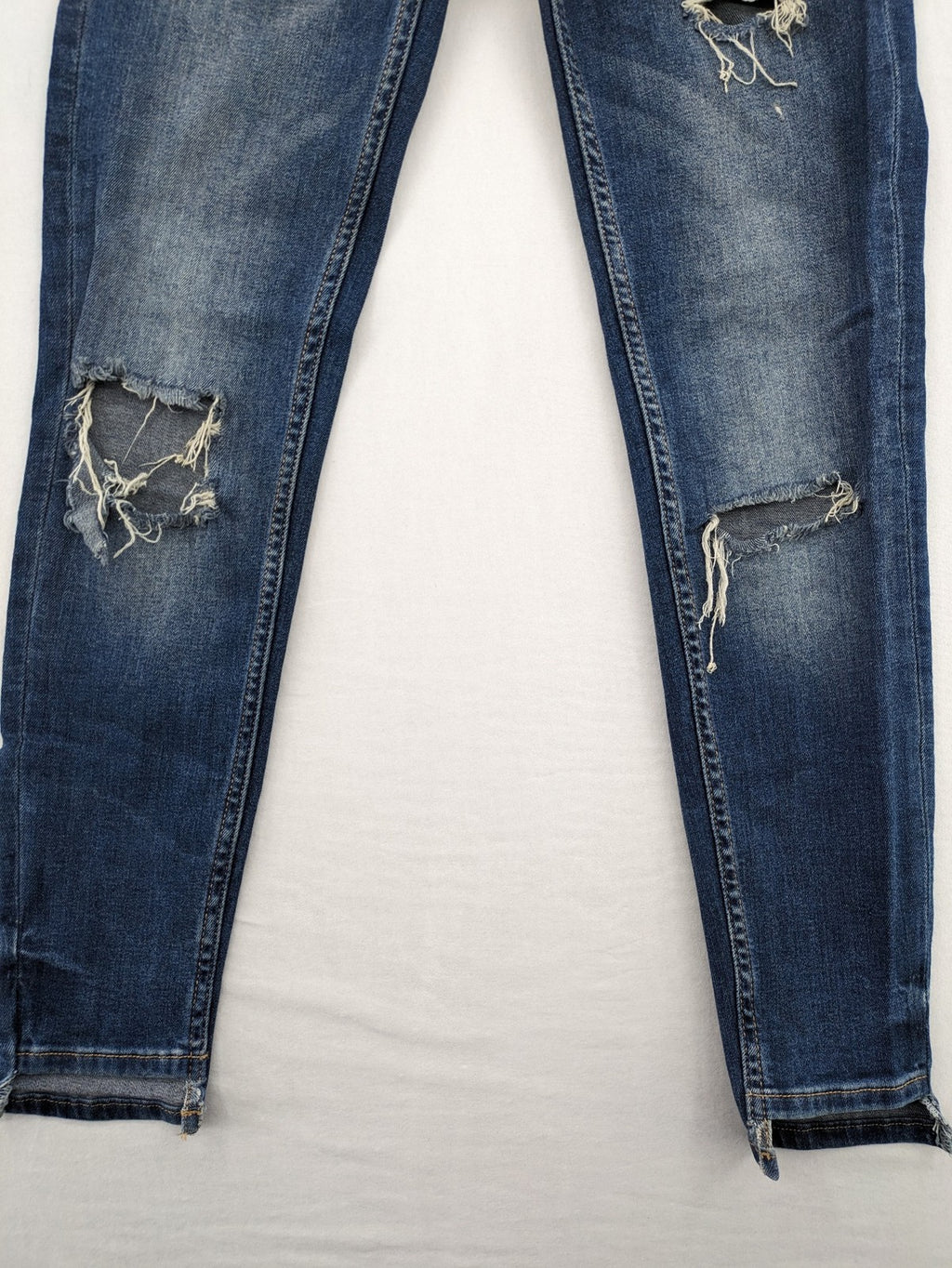 Zara Basic blue skinny jeans with destroyed knee details and frayed hem.