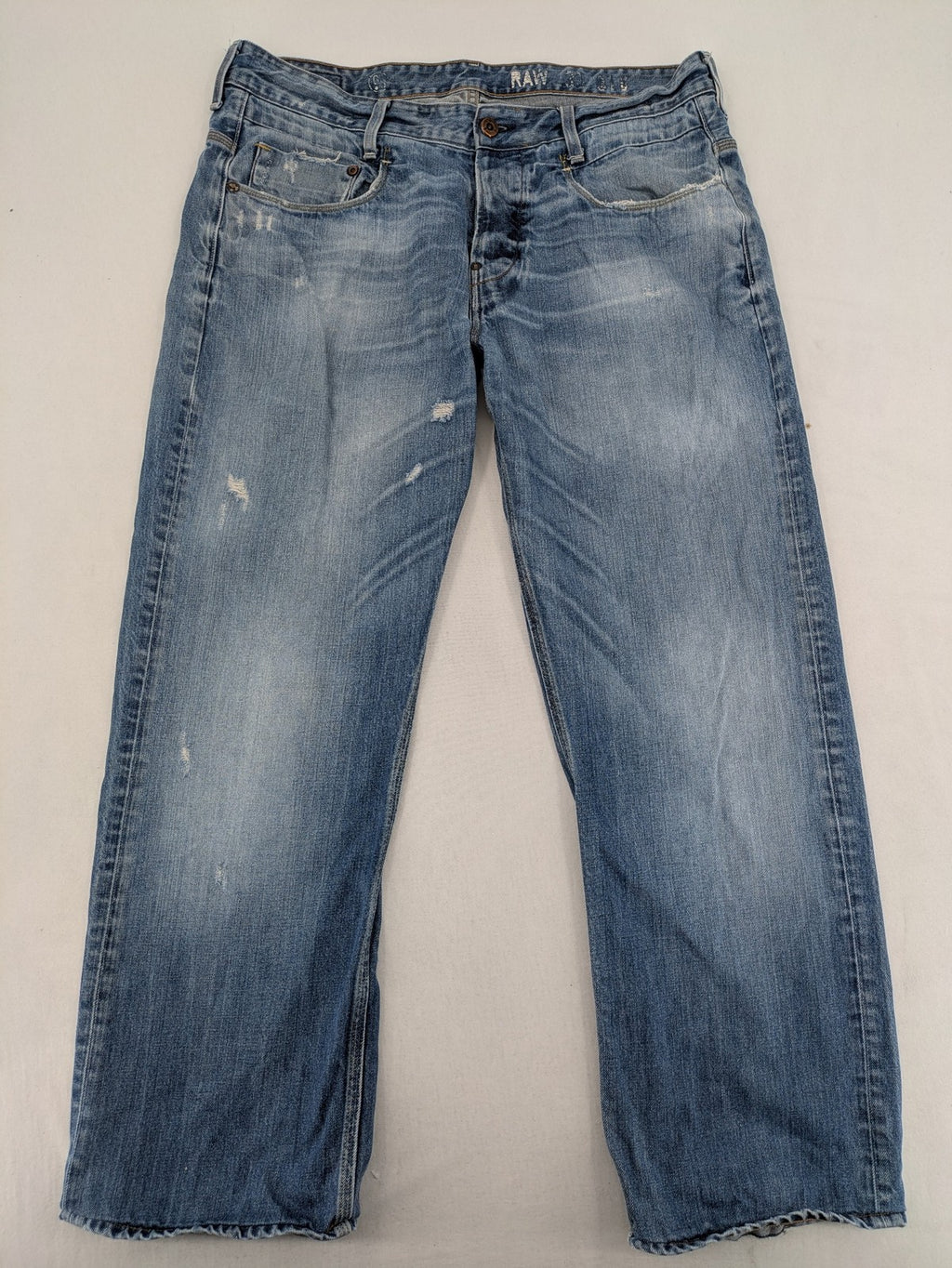 G-Star Raw blue straight jeans with distressed details and classic button fly.