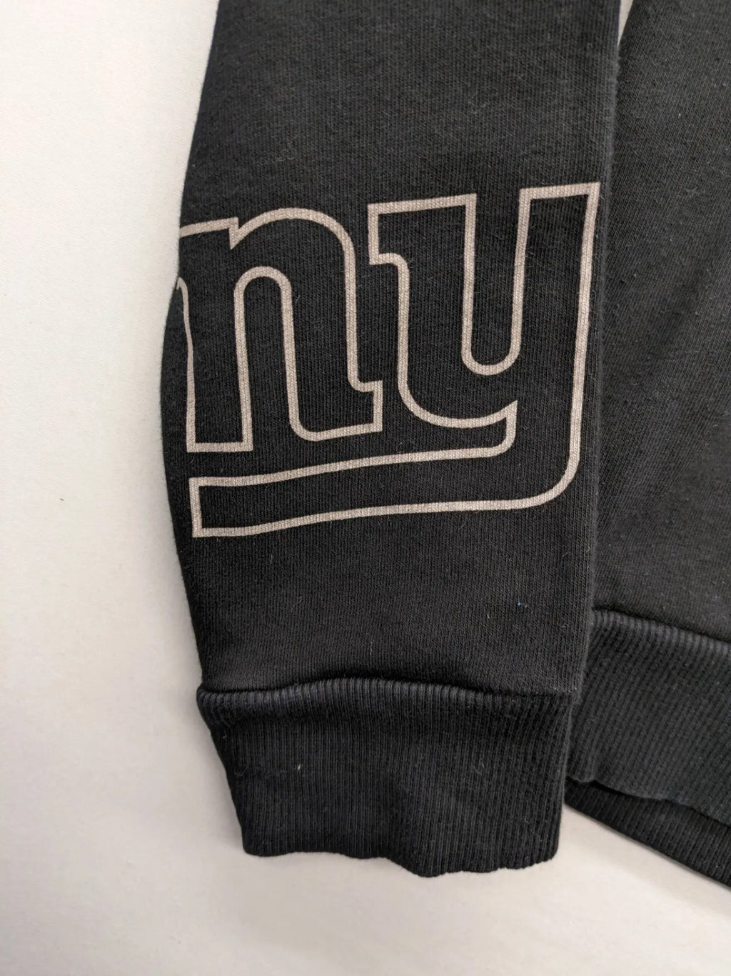 NFL black hoodie all-over team logo print, adjustable hood, cotton blend material.