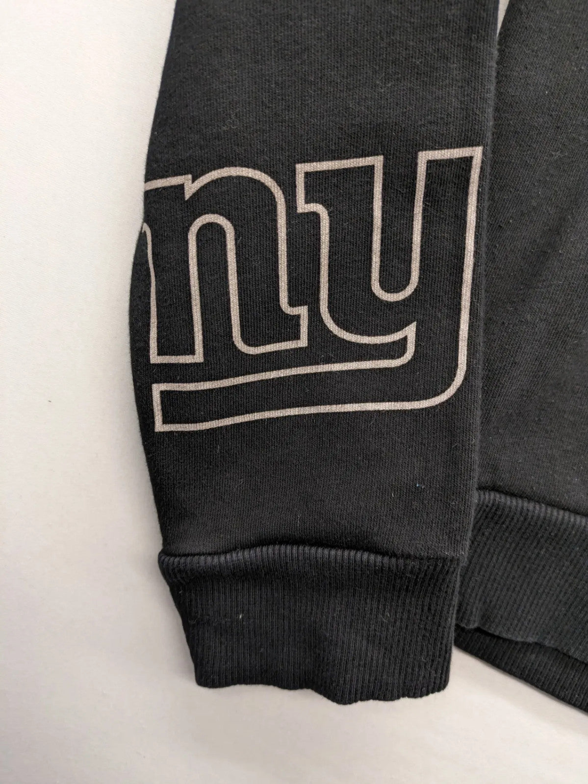 NFL black hoodie all-over team logo print, adjustable hood, cotton blend material.