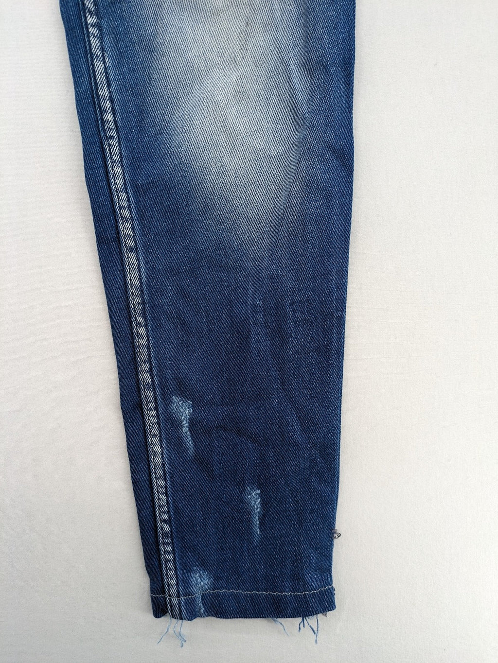 Diesel blue straight jeans with distressed details and ripped accents, made of cotton.