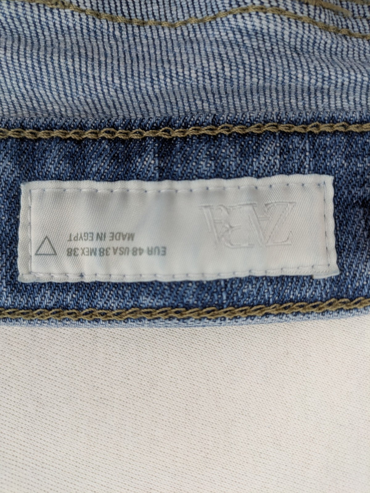 Zara blue straight jeans with distressed ripped knees and button-fly closure.