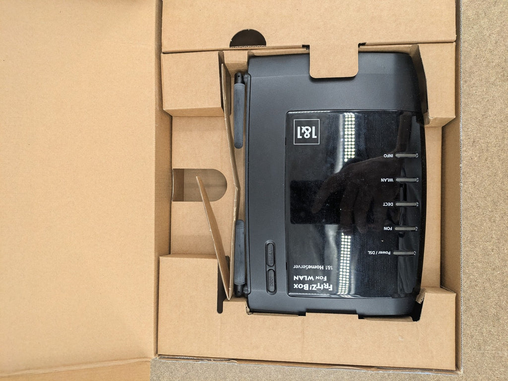 AVM black wireless router with integrated DSL modem and 1&1 logo.