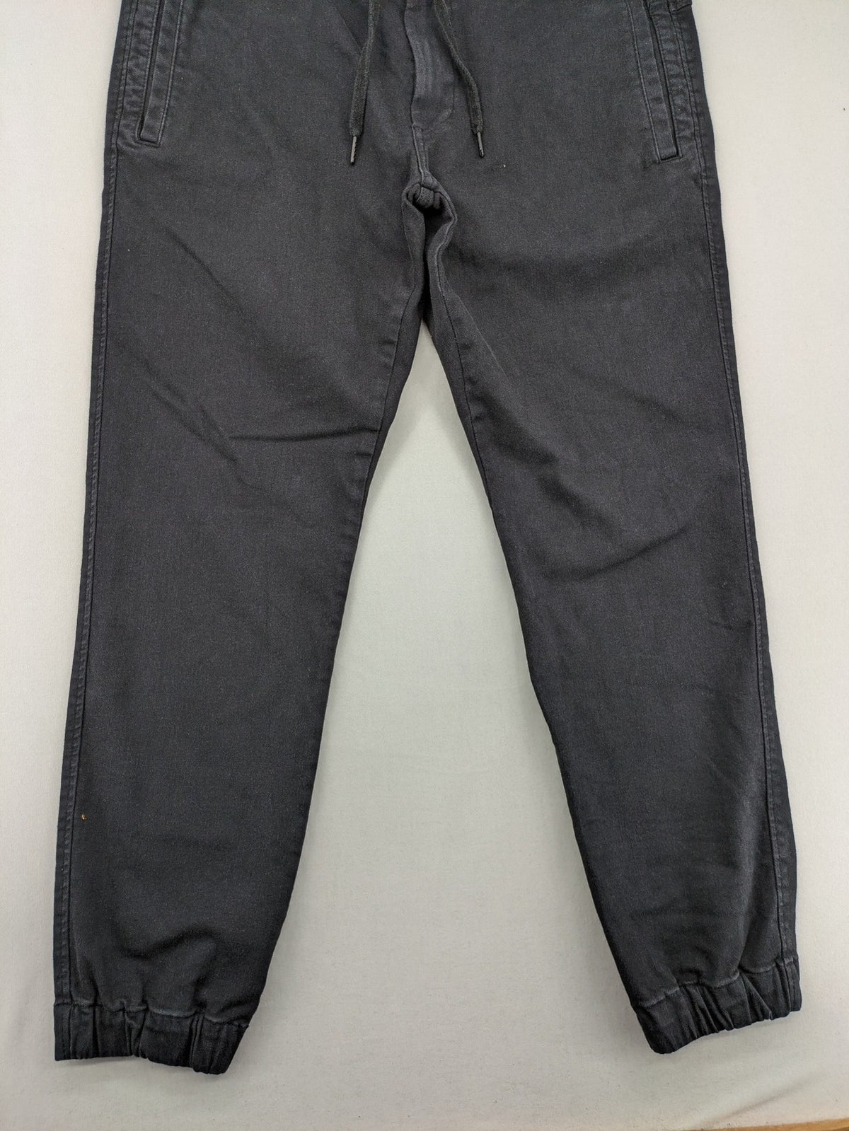 C&A grey jogger pants with elastic cuffs, drawstring waist, and multiple pockets.