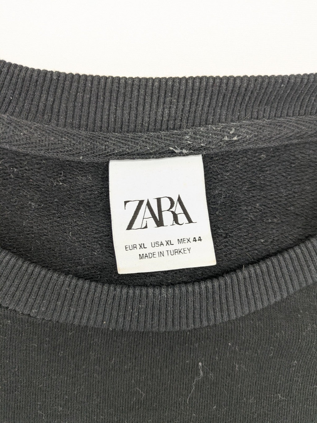 Zara grey turtle neck jumper with skull, scorpion, flame, and eagle embellishments.