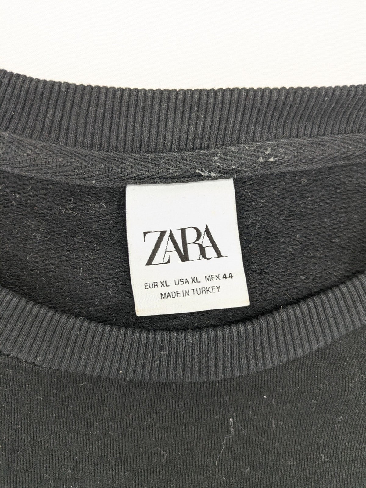 Zara grey turtle neck jumper with skull, scorpion, flame, and eagle embellishments.