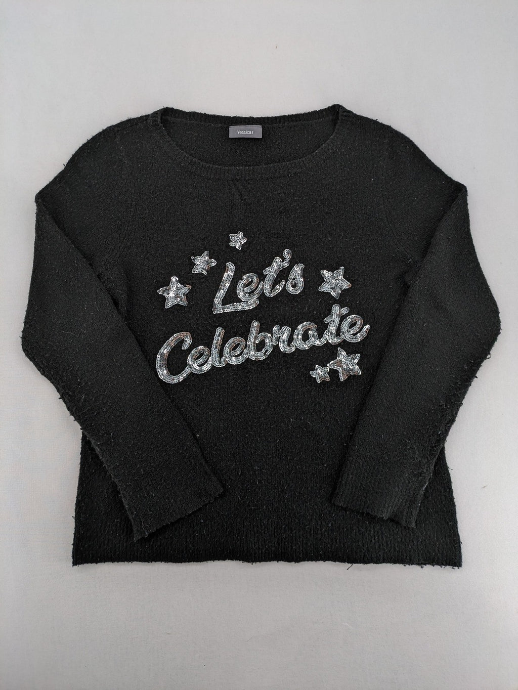 Yessica black turtle neck jumper with sequin "Let's Celebrate" graphic and star details.