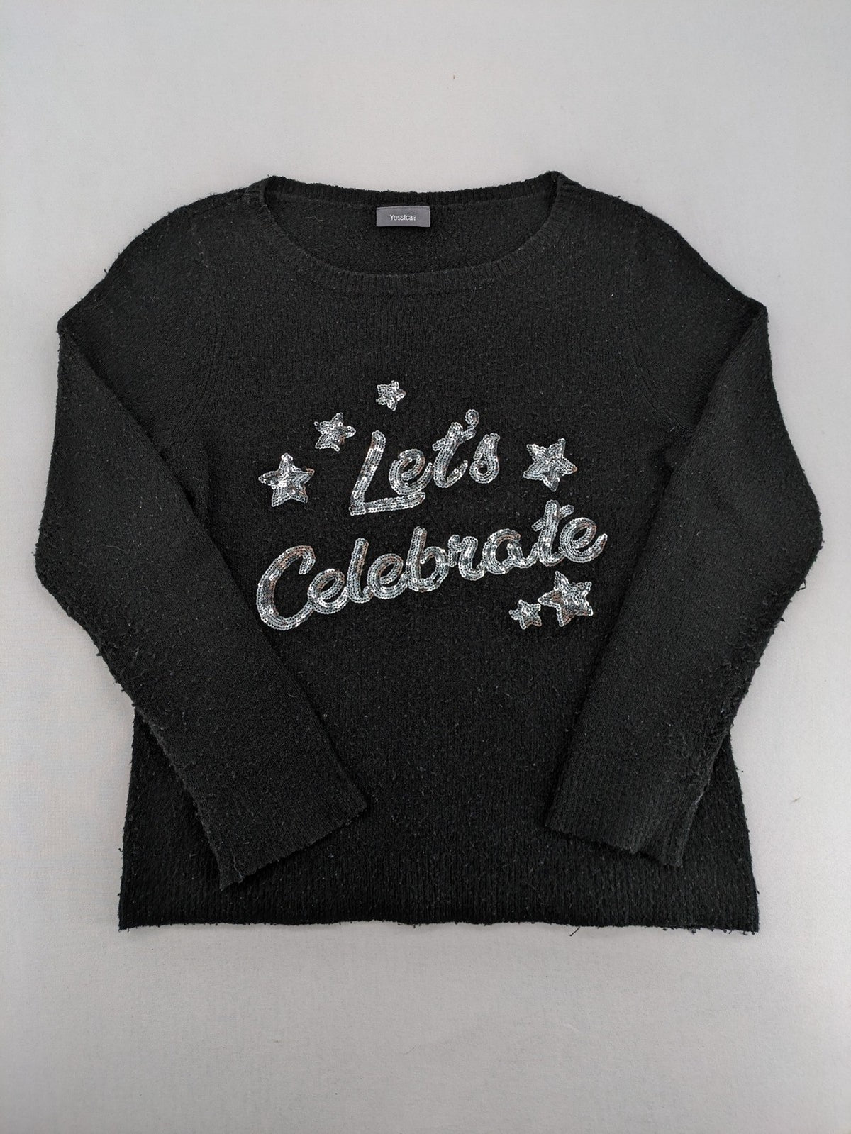 Yessica black turtle neck jumper with sequin "Let's Celebrate" graphic and star details.