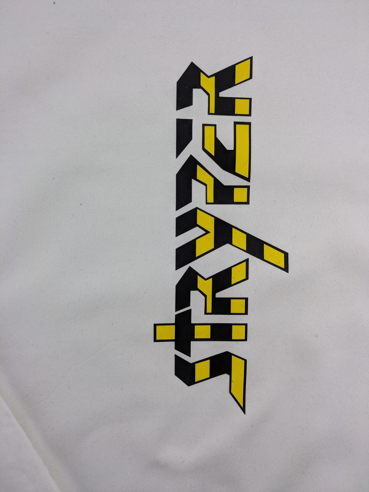 Stryper turtle neck jumper black with yellow vertical logo graphic on chest.