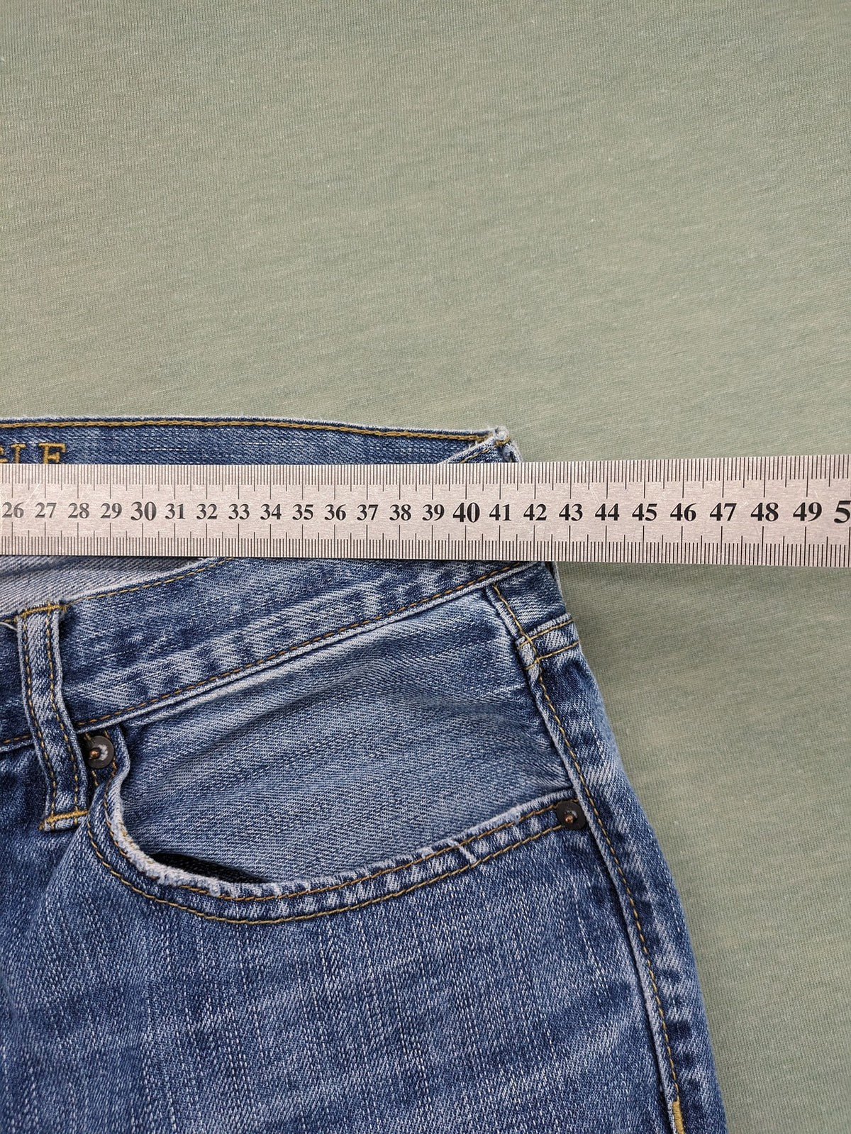 American Eagle Outfitters blue straight jeans with distressed detailing and classic five-pocket design.