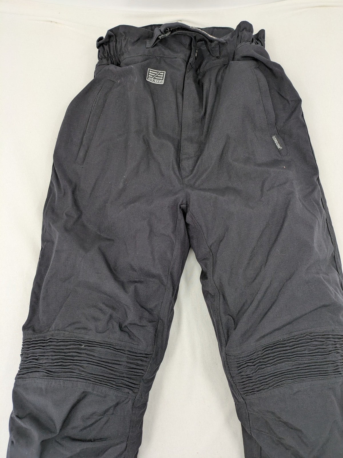 Aero black chaps Cordura fabric with ribbed knee inserts and adjustable waistband.