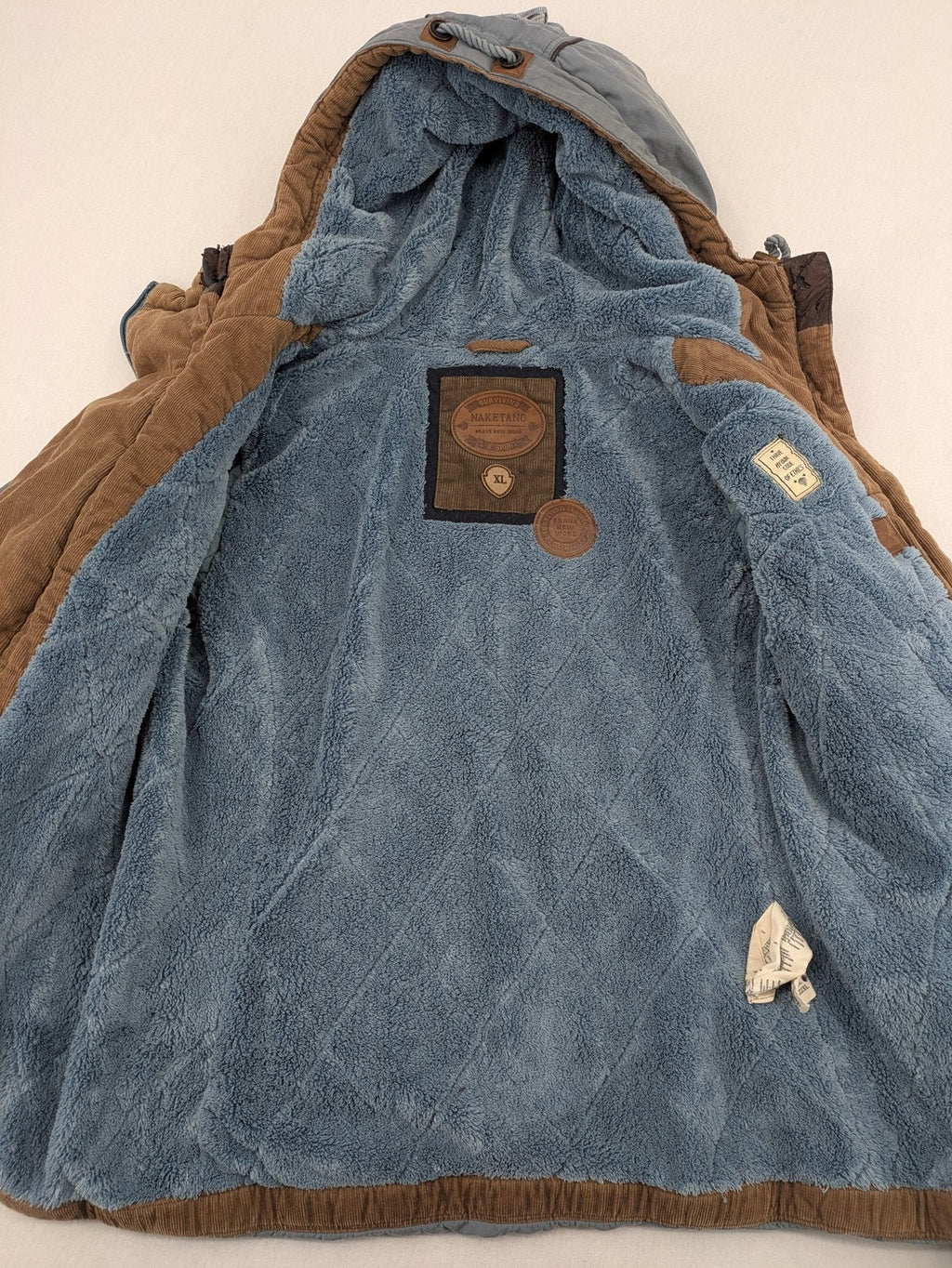Naketano blue jacket with teddy fleece lining, hood, and leather appliqués.