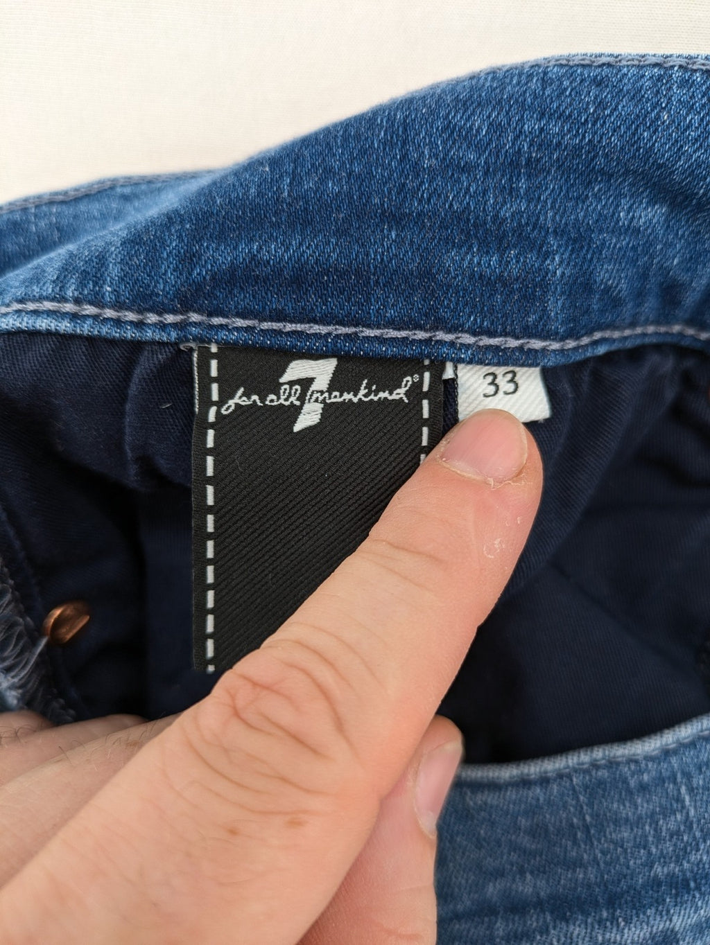 7 For All Mankind blue straight jeans with 5-pocket design and logo on back pocket.