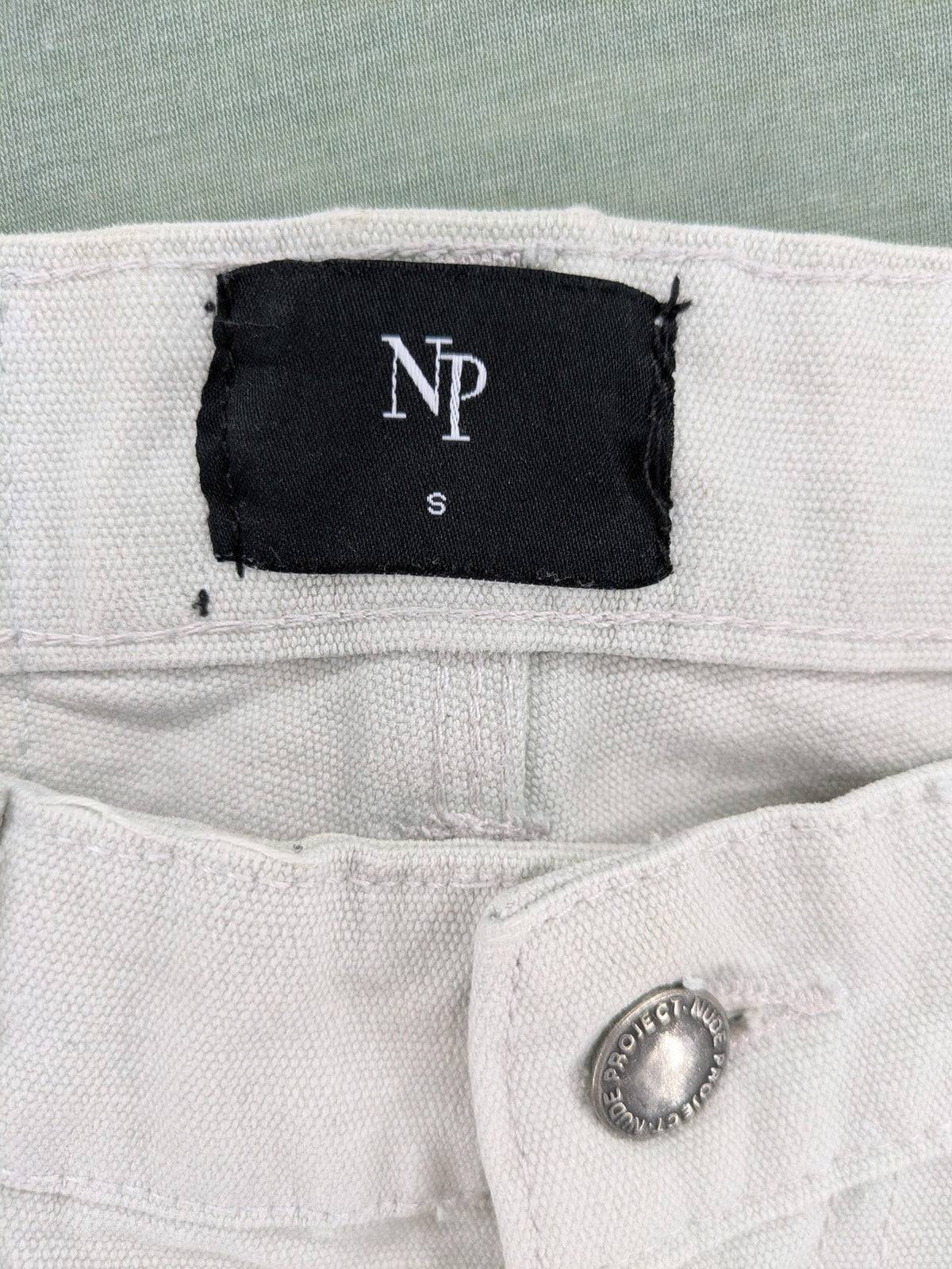 NUDE beige pants with double knee reinforcements and multiple utility pockets.