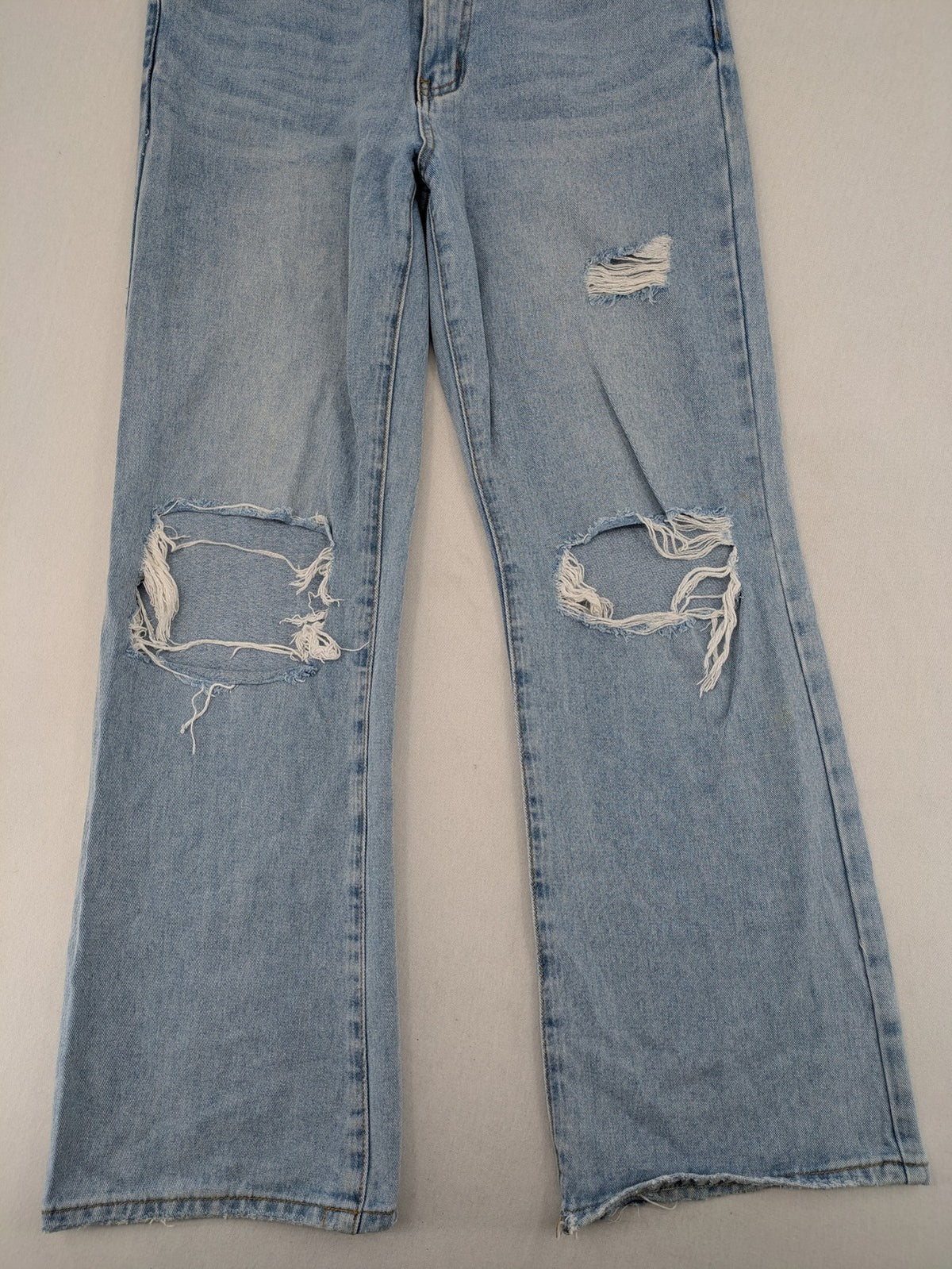 Laulia blue wide leg jeans with distressed knee rips and high waist design.