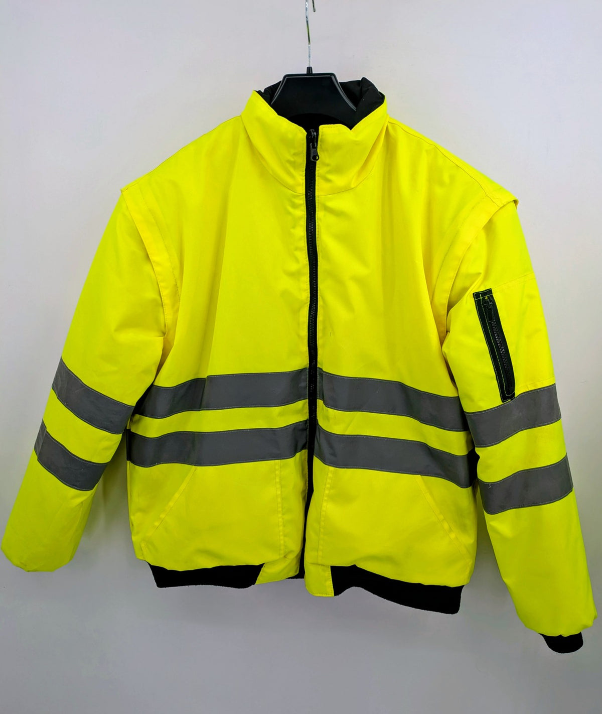 Hüren OHG grey and neon yellow safety jacket with reflective stripes and zippered arm pocket.