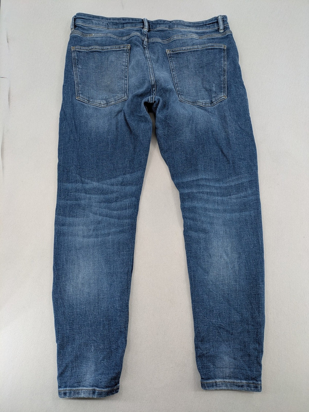 Zara blue straight jeans with distressed ripped knees and button-fly closure.