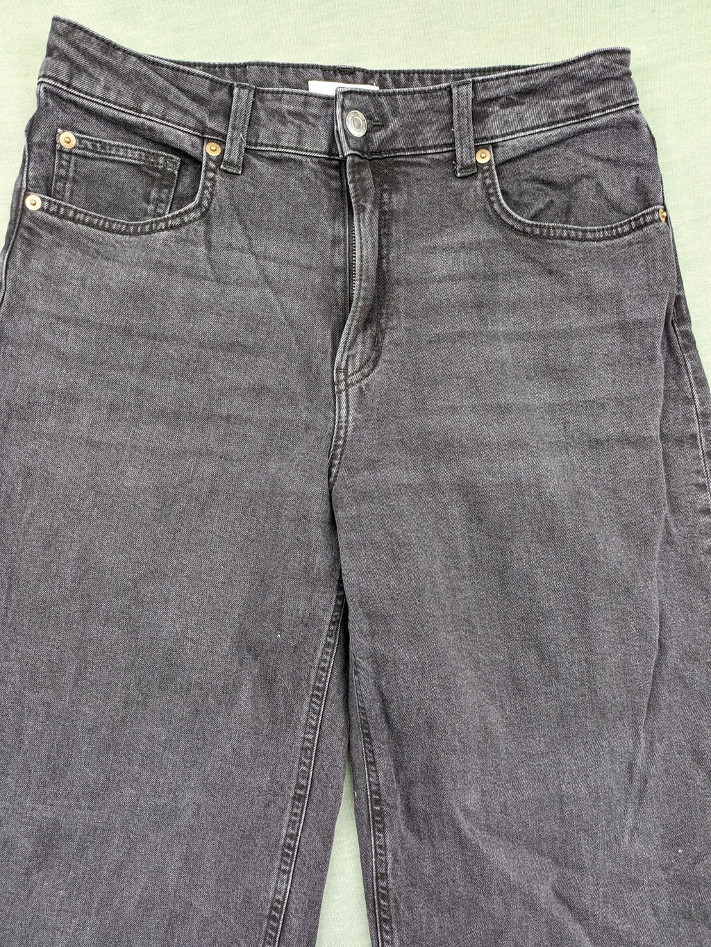 H&M black grey wide leg cropped jeans with frayed hem and high waist design.