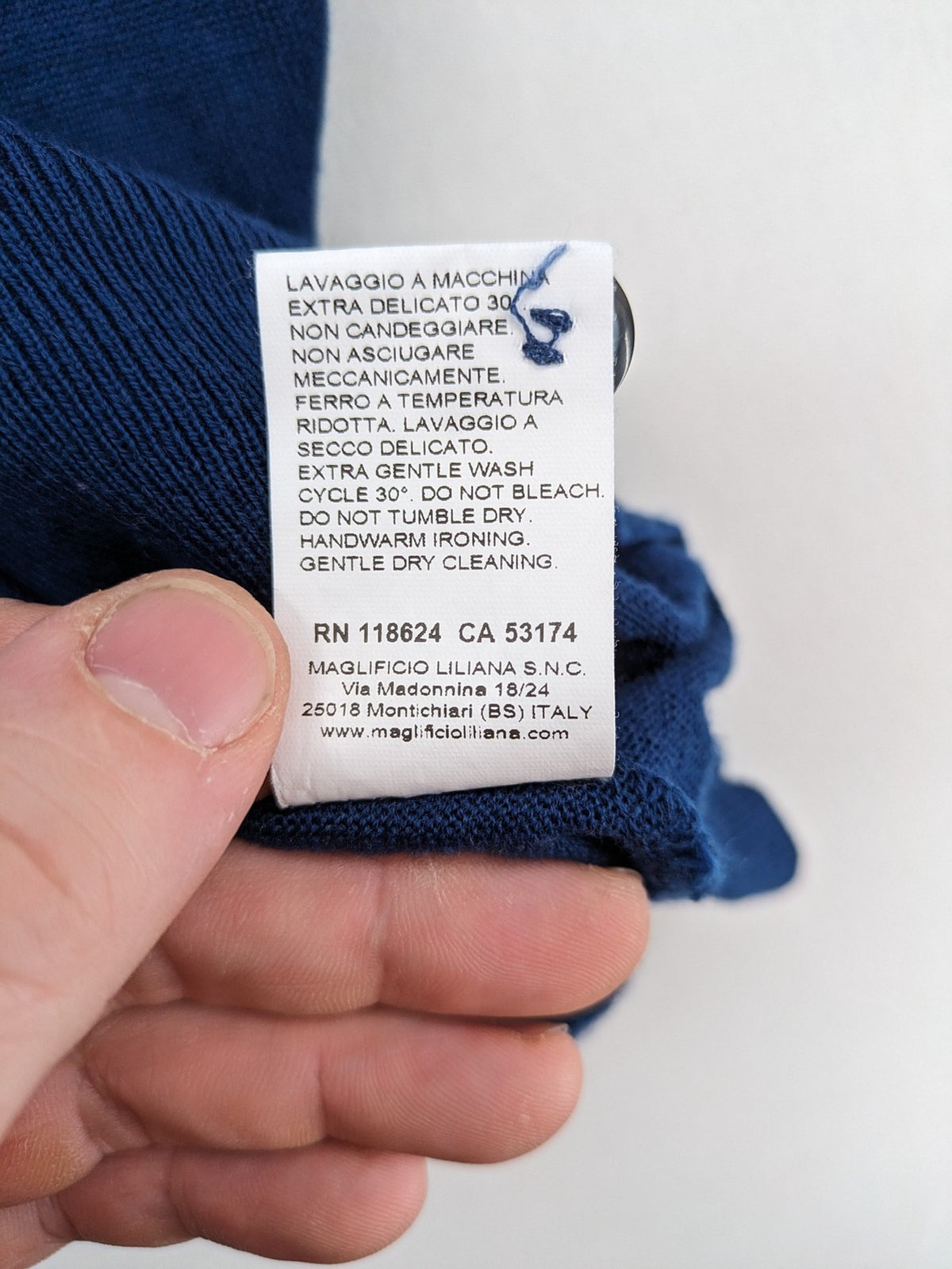 Montechiaro blue turtle neck jumper with V-neck, button placket, and sleeveless design.