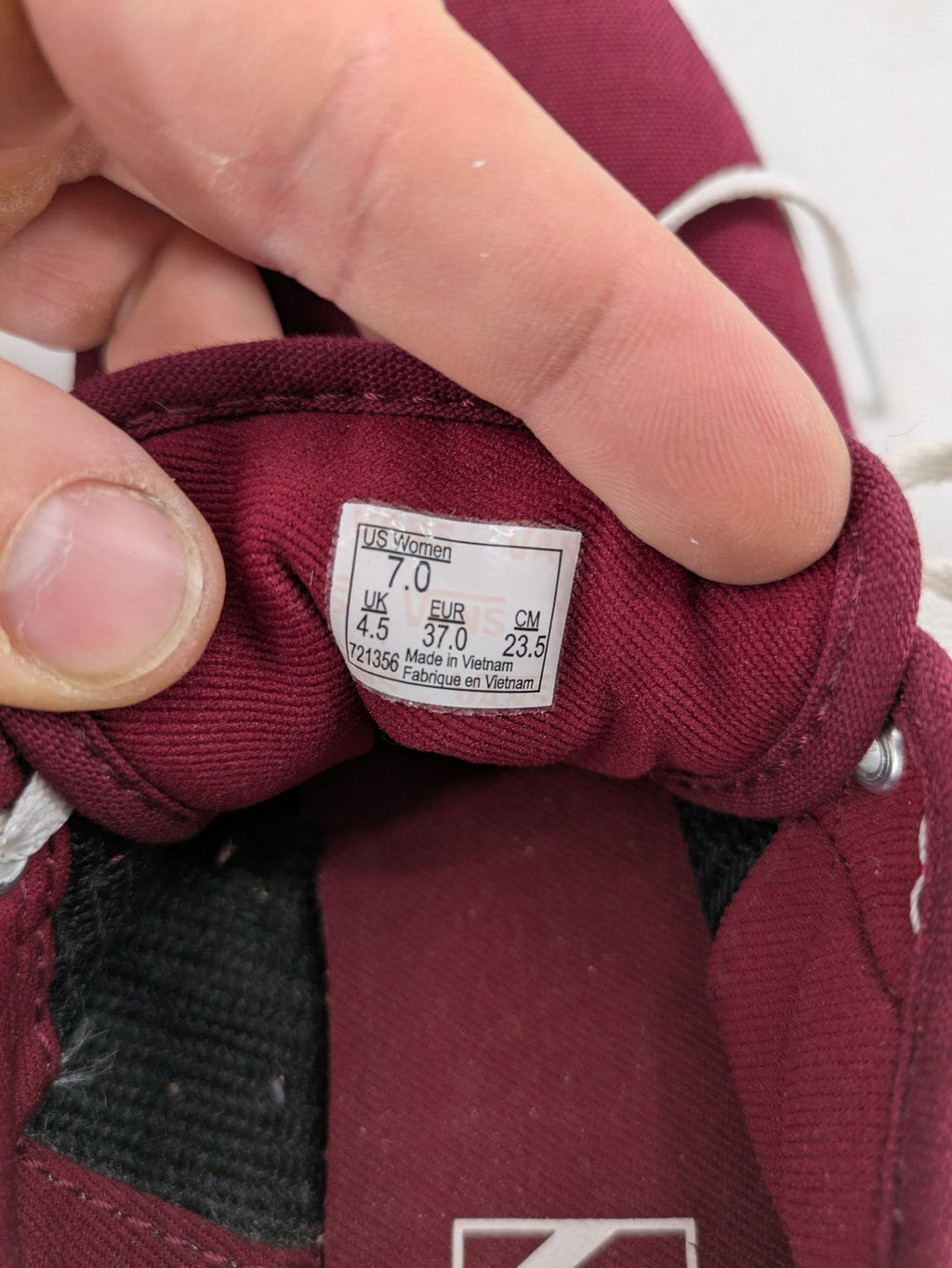 Vans low-top sneakers burgundy canvas with white logo and classic waffle sole.