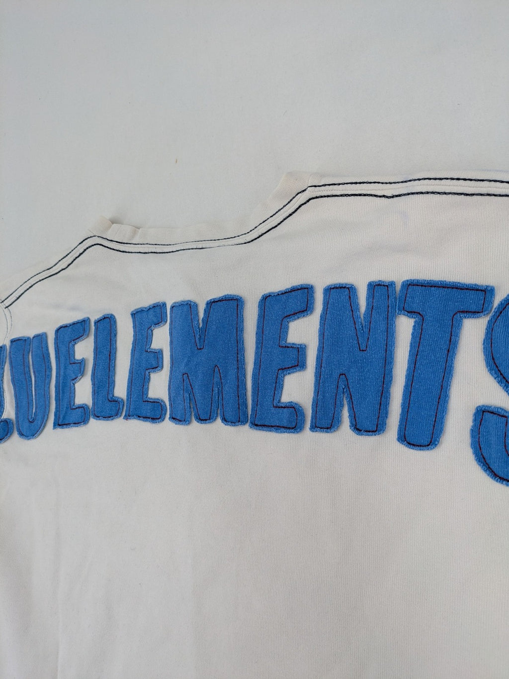 Zuelements black turtle neck jumper with red wing graphic and large blue logo.