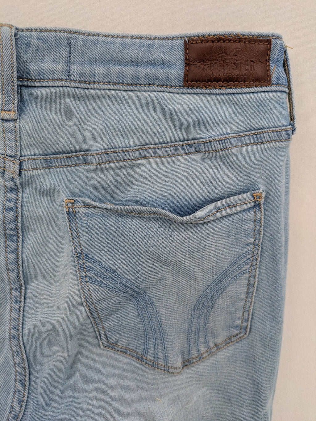 Hollister blue high-rise crop super skinny jeans with distressed rips and frayed hem.