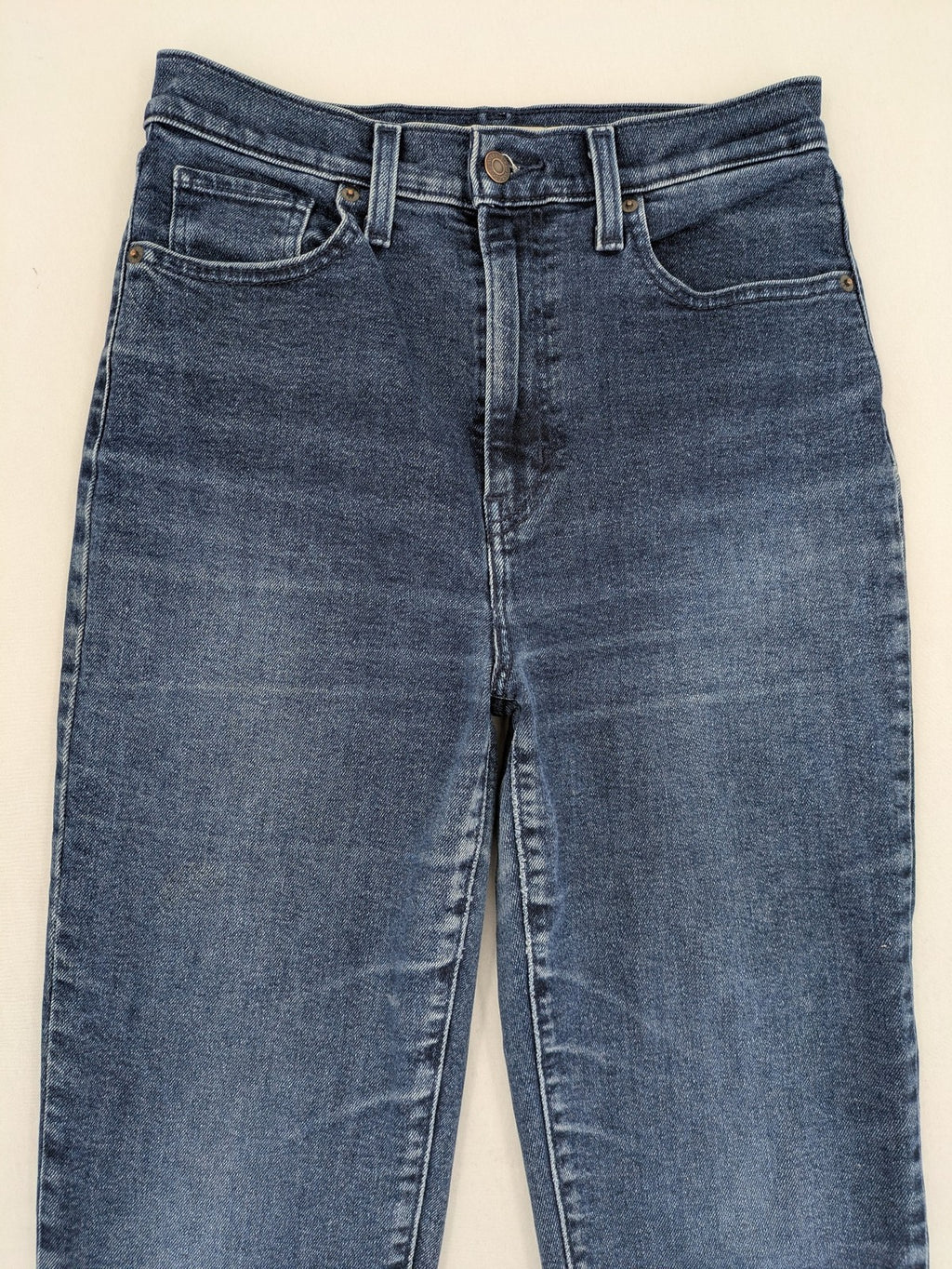 Levi's high waisted taper jeans dark blue 5-pocket design with zipper and stretch material.